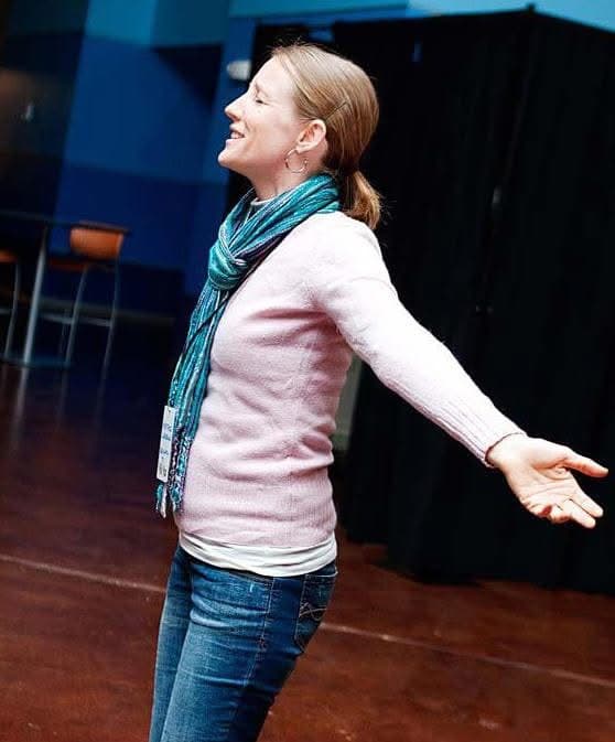 Heather with arms outstretched and an open palm