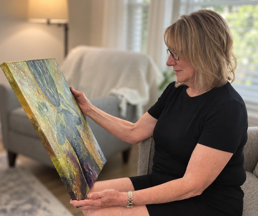 Lois seated at home, holding and contemplating the painting she has received.
