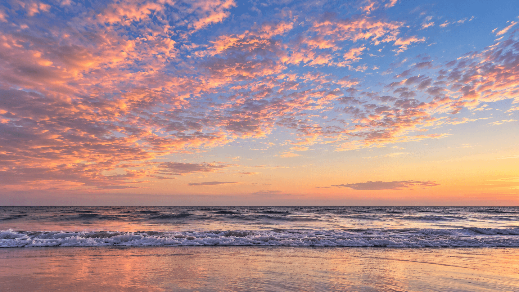 Pastel sunset over ocean waves.