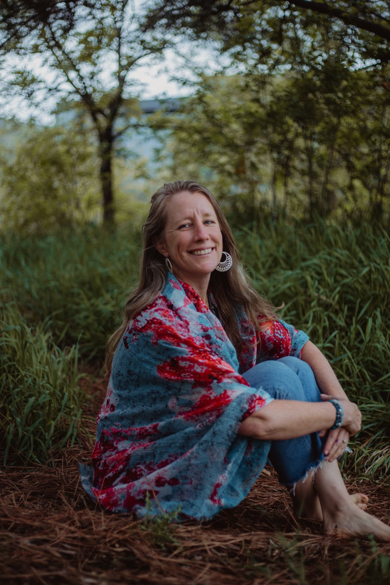 Heather seated on the ground in a patterned wrap