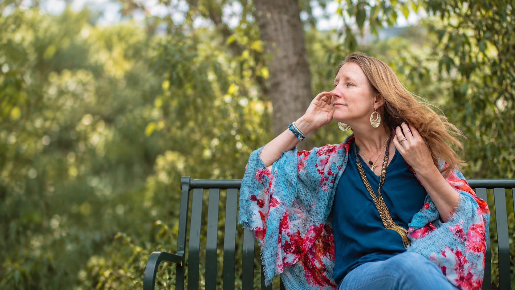 Heather looking into the distance while seated on a garden bench